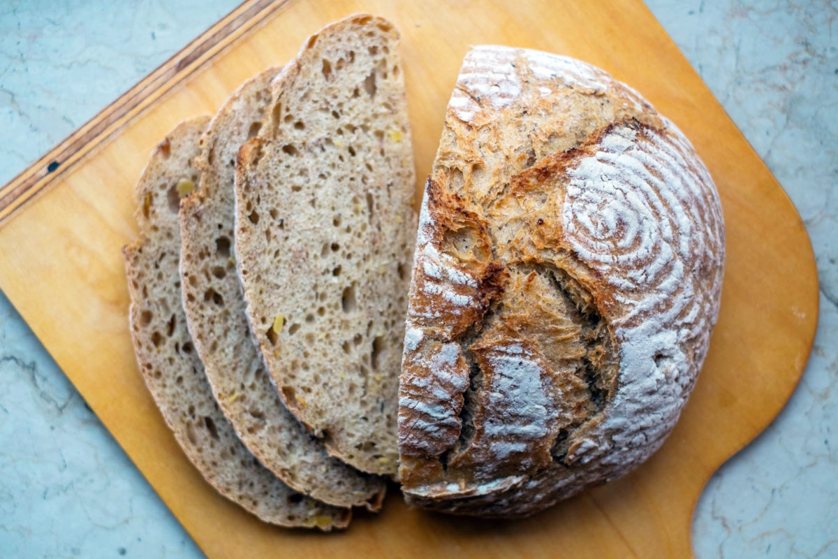 Ein Kanten Kartoffelbrot mit drei aufgeschnittenen Scheiben