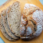 Ein Kanten Kartoffelbrot mit drei aufgeschnittenen Scheiben