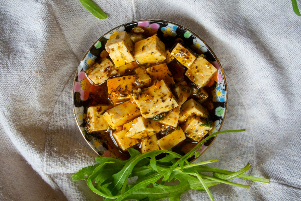Teller mit marinierten Tofuwürfeln und Rauke